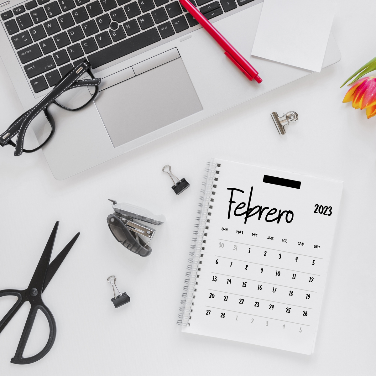Schreibtisch mit Kalender Februar 2023 und Büromaterialien.