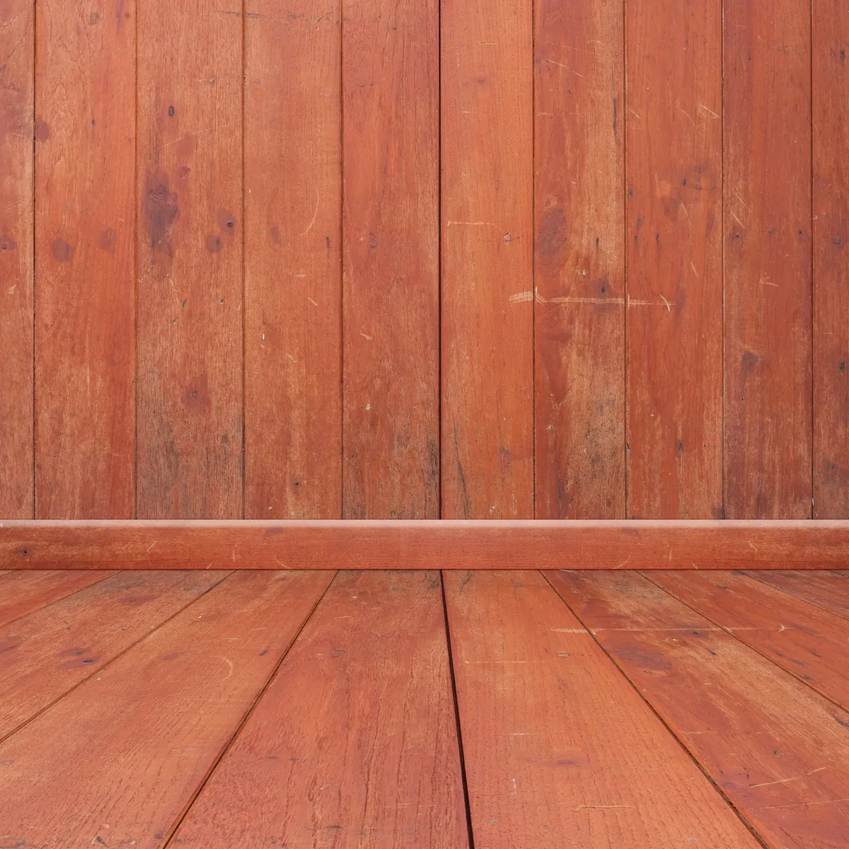 Rustikaler Raum mit roten Holzdielen an Wand und Boden.