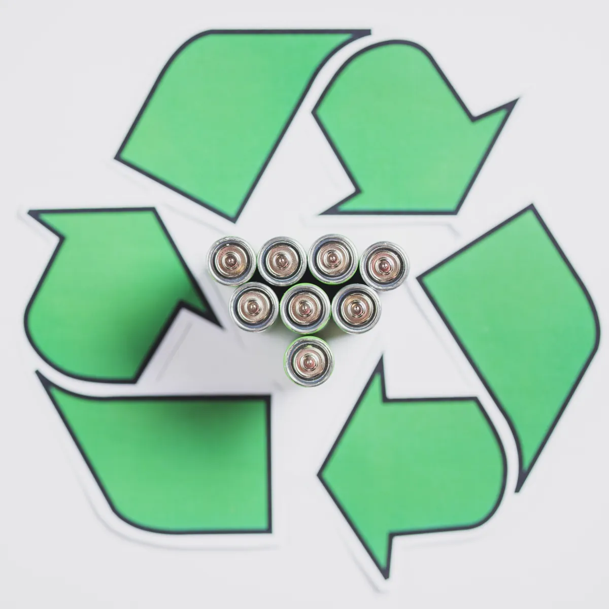 Batterien im Recycling-Symbol auf weißem Hintergrund.