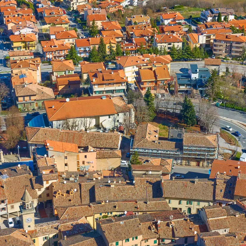 Luftaufnahme einer italienischen Stadt mit roten Ziegeldächern.